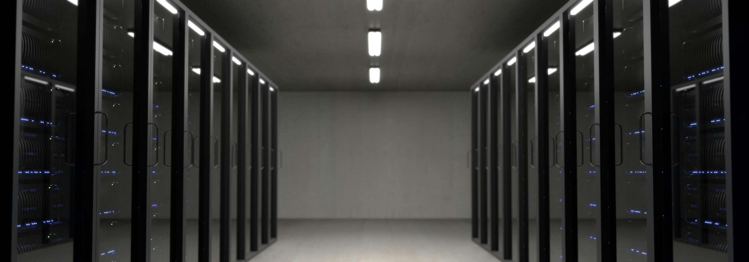 A data hall: rows of server racks either side of a lit aisle